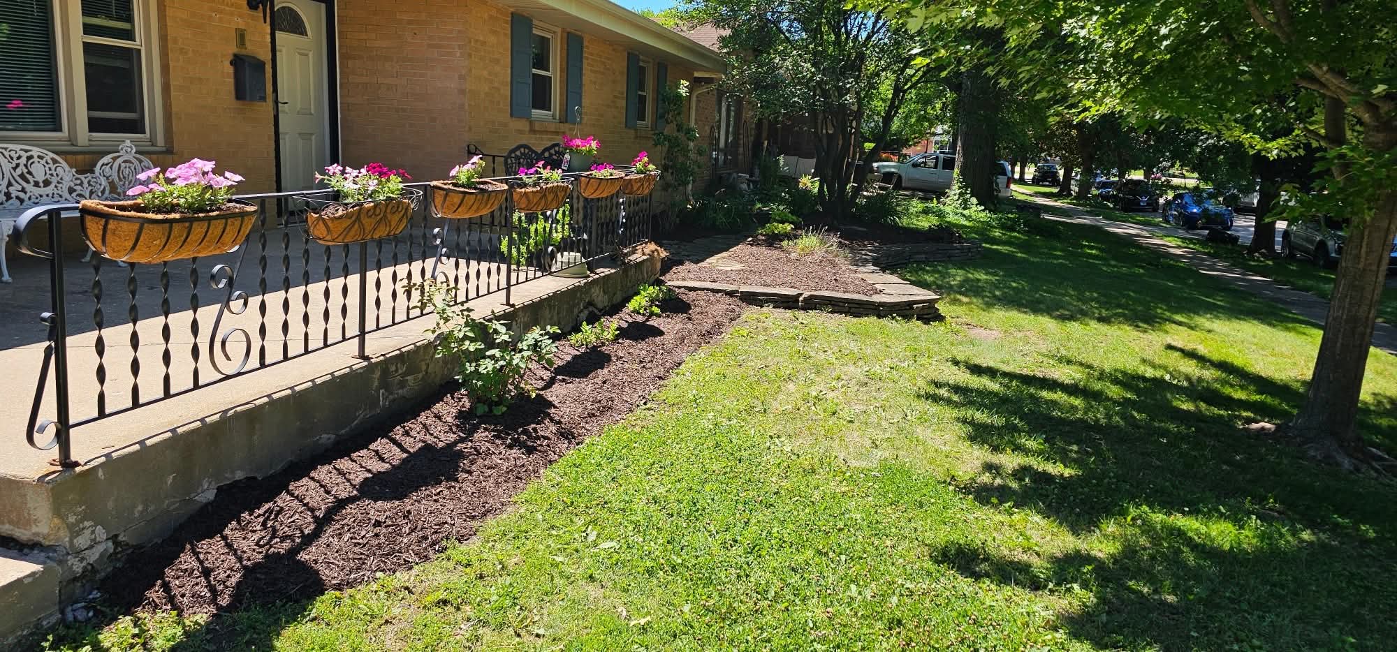 After: fresh mulch bed along the porch with flower baskets